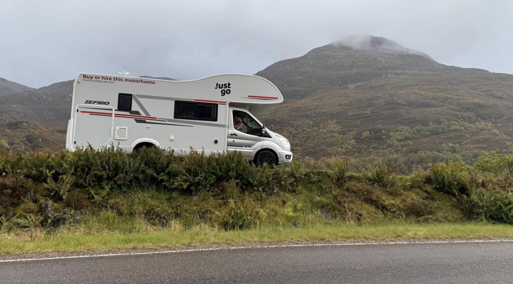 "Motorhome parked along the scenic North Coast 500 route, surrounded by rugged landscapes, winding roads, and breathtaking coastal views in the Scottish Highlands."